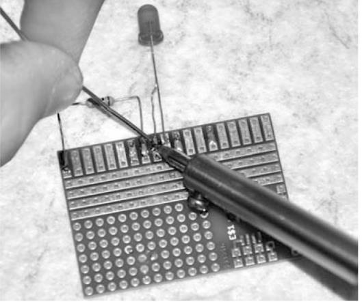4.11 Circuit simplu cu led Folosind schiţa de lipire realizată puteţi acum să treceţi la lipire. Începeţi cu rezistenţa. Aceasta nu este o componentă sensibilă, ce poate fi manevrată ca şi un jumper.