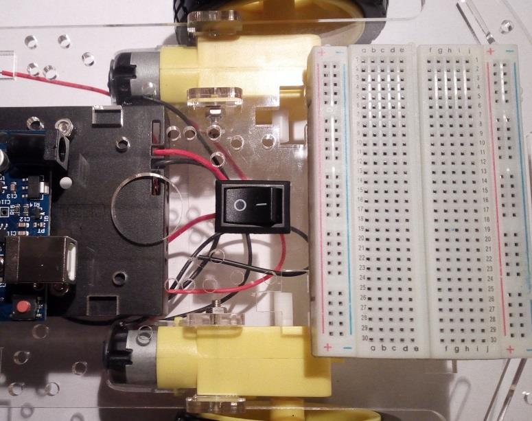 8 Τοποθέτηση breadboard και αισθητήρα HC-SR04 Τοποθετούμε το breadboard στην μπροστινή πλευρά του οχήματος, κοντά στο διακόπτη, όπως φαίνεται στην