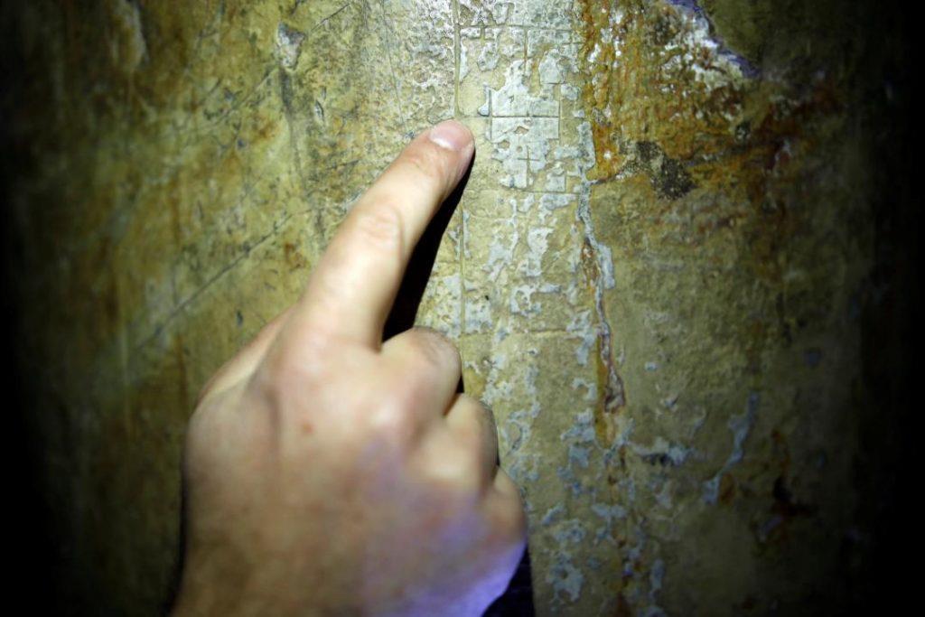 Image 2: Ένας ερευνητής επισημαίνει σημάδια σταυρών που άφησαν οι προσκυνητές σε έναν πυλώνα στην αίθουσα του Υπερώου, τον χώρο που λατρεύτηκε από τους Χριστιανούς ως τόπο του Μυστικού Δείπνου του